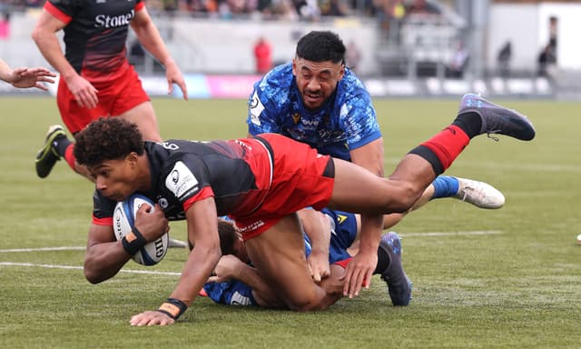 Noah Caluori of Saracens is held by Alex Newsome and Irae Simone